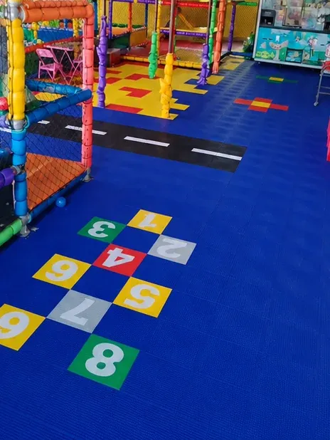 Amarelinha de 1 a 8 recortada em piso modular azul no espaço kids do Pedrão Lanches, em Valinhos