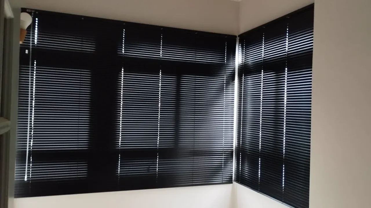 Persiana horizontal preta instalada em janela de canto
