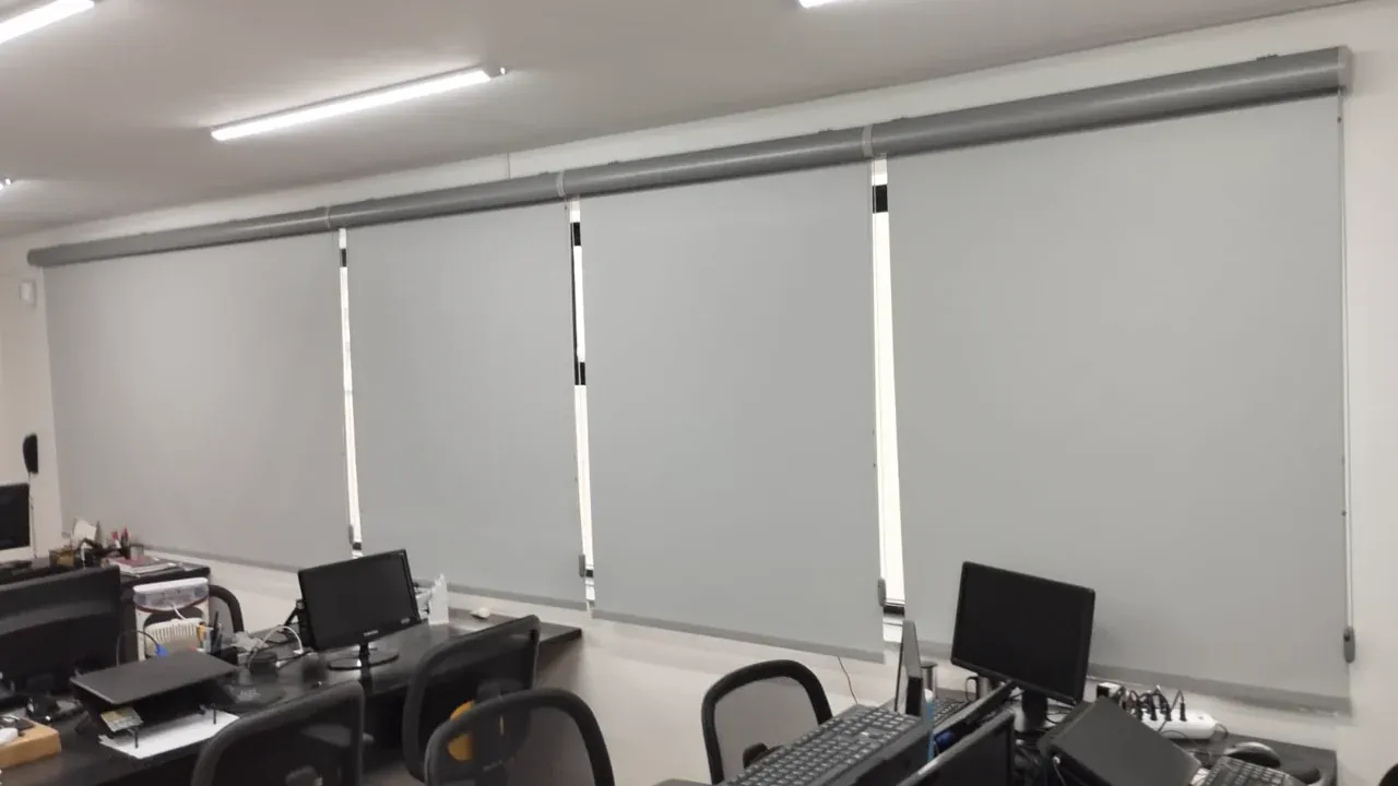 Conjunto de persianas rolo blackout em ambiente corporativo