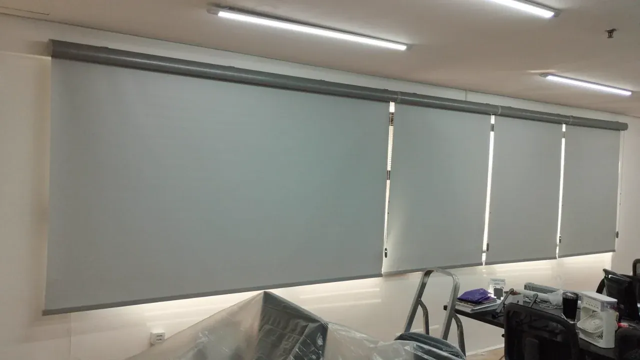 Instalação de persianas rolo blackout cinza em escritório