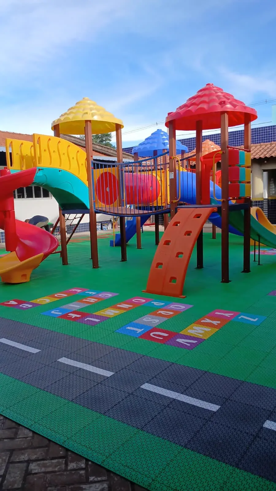Playground coberto com piso modular azul e trilha de alfabeto