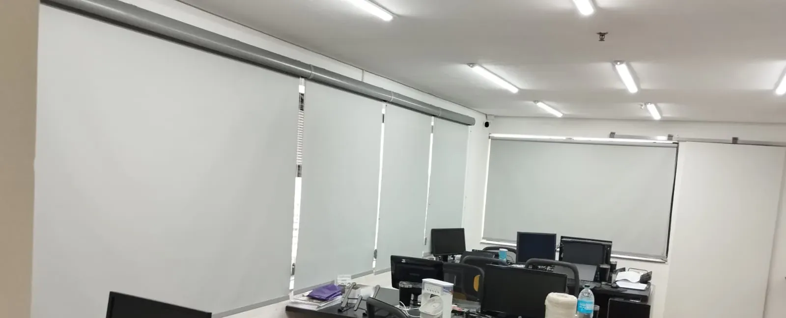 Persiana rolô blackout cinza sob medida em faixa de janelas