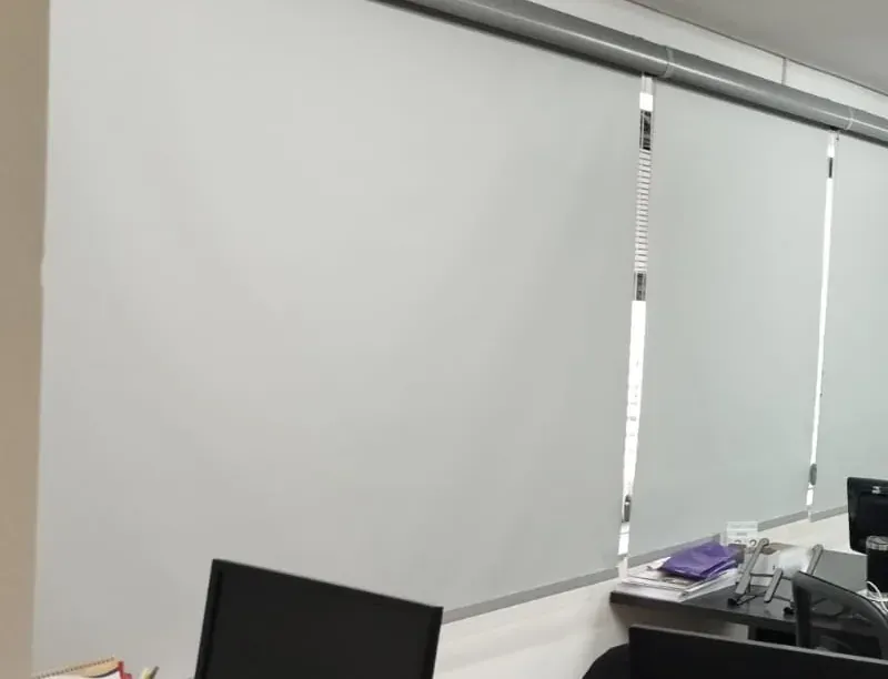 Close de persiana rolô blackout cinza, tecido e tubo do mecanismo