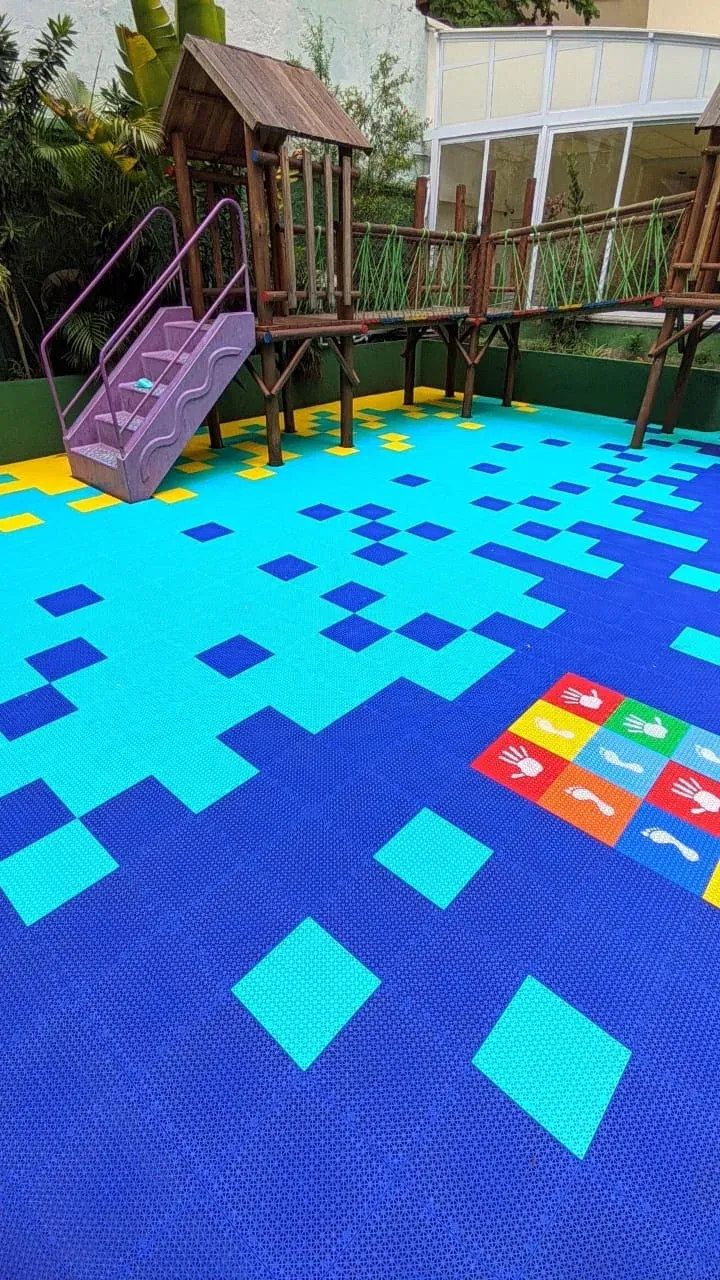 Piso modular em placas azuis e amarelas em playground
