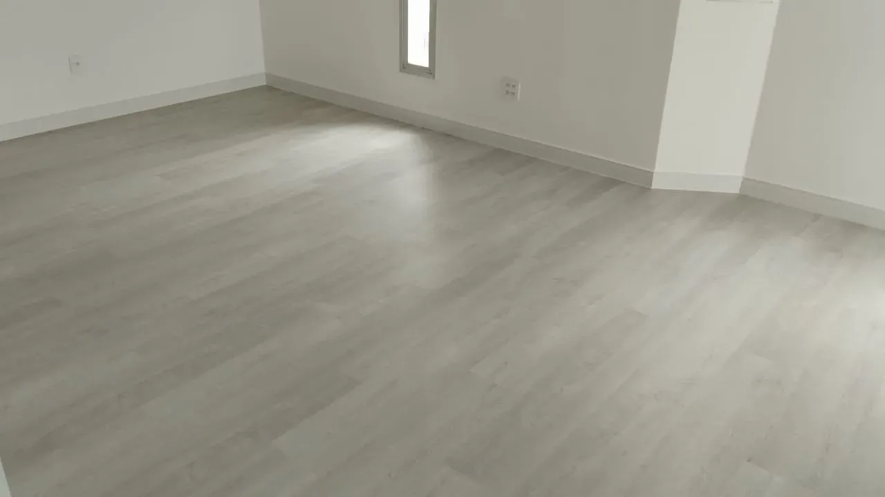 Piso vinílico Statofloor em régua, instalado em sala com rodapé branco